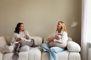 Two women feeding their babies with a neutral tone Nursing Pillow