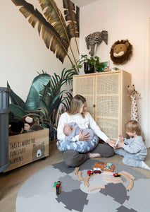 Mother nursing an infant with bbhugme pregnacy pillow while playing with a toddler 