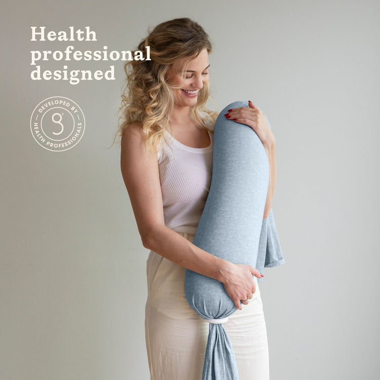 Woman holding a blue bbhugme nusing pillow with 'Health professional designed' text on a plain background