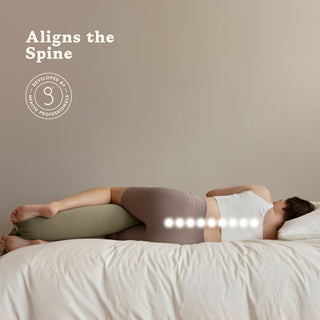 Person lying on a bed with a bbhugme pregnancy pillow under their head, aligning the spine.