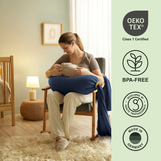 Woman holding a baby in a room with Oeko-Tex, BPA-Free, and Made in Germany certification logos on the right bbhugme pregnancy pillow